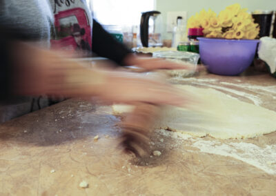 Moving hands rolling out pie dough with a rolling pin.